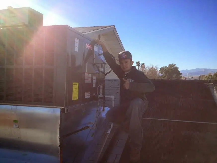 HVAC technician performing Heat Pump Repair on a rooftop unit in The Village